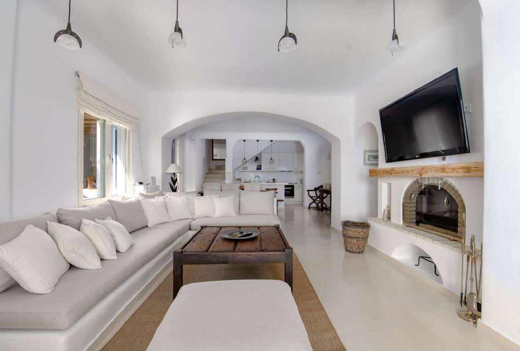 White walls, modern furniture, and living room amenities in Mykonos' top rental home.