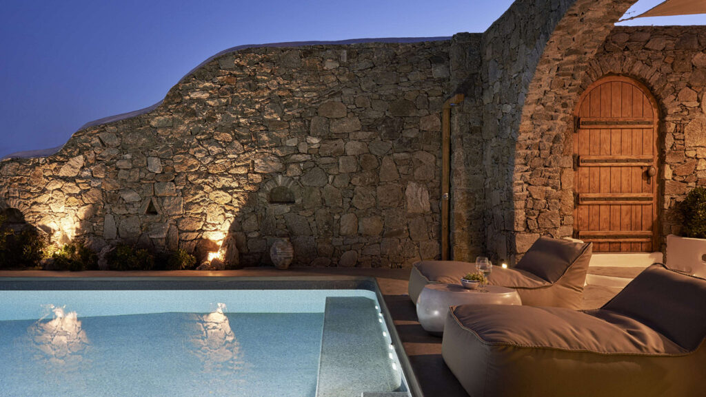 A sip of wine next to a swimming pool in the splendid villa for rent, Mykonos, Greece.