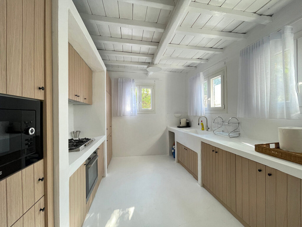 Kitchen with a lot of space, in white and wooden design, Mykonos finest rental villa.