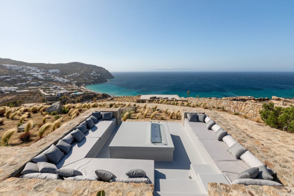 Spectacular sea view from the open living area with cozy sofa in Mykonos' best rental villa.