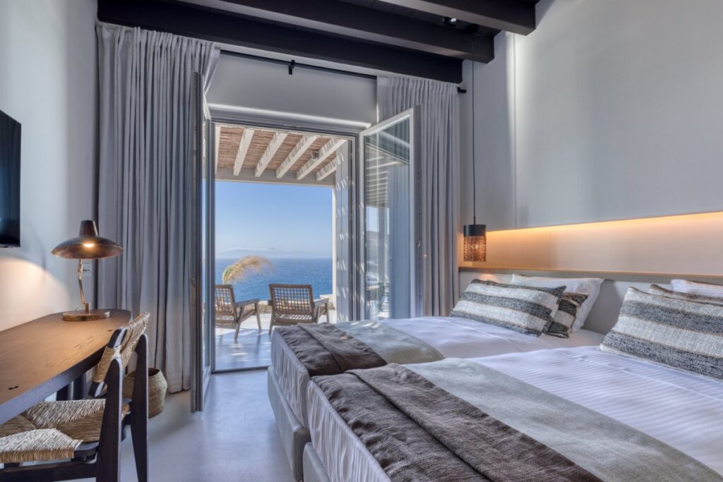Panoramic sea views from the cozy, modern bedroom in Mykonos lavish villa for rent.