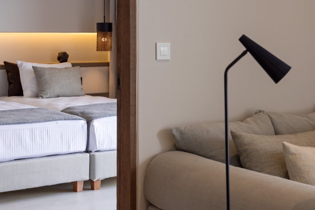 Sofa, lamp, and bed in Mykonos lavish villa for rent.
