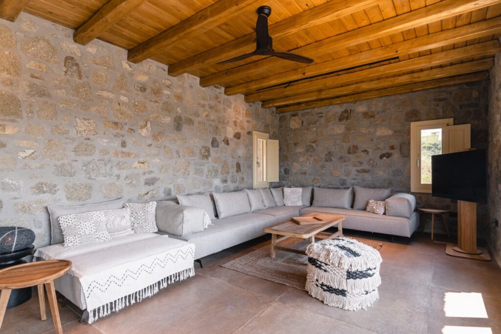 Comfy and cozy living room, modern furniture, and stone walls, Mykonos private rental home.