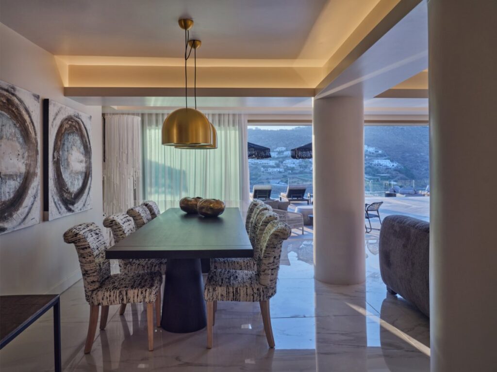 Hanging golden chandeliers and lunch table in Mykonos finest rental villa.