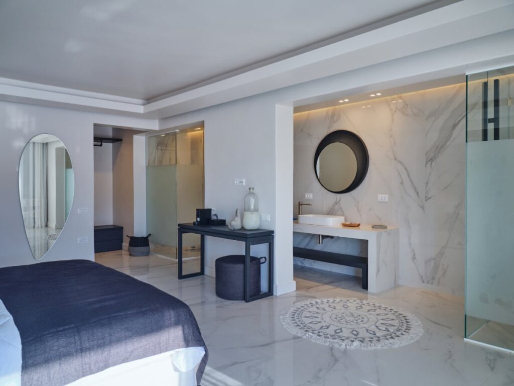 Sleek and stylish Mykonos villa bedroom with high-end bathroom amenities and a dreamy bed, Mykonos rental villa.