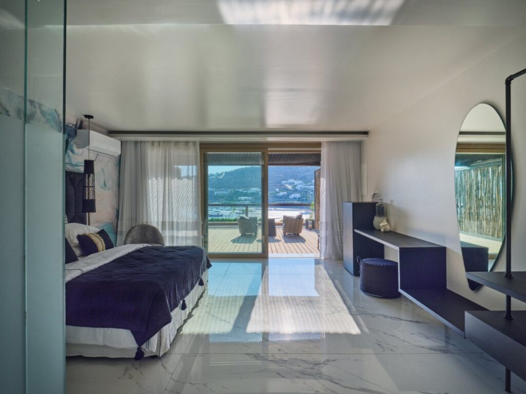 The bedroom is designed for ultimate comfort and is complete with modern amenities and a cozy bed. Mykonos deluxe rental villa.
