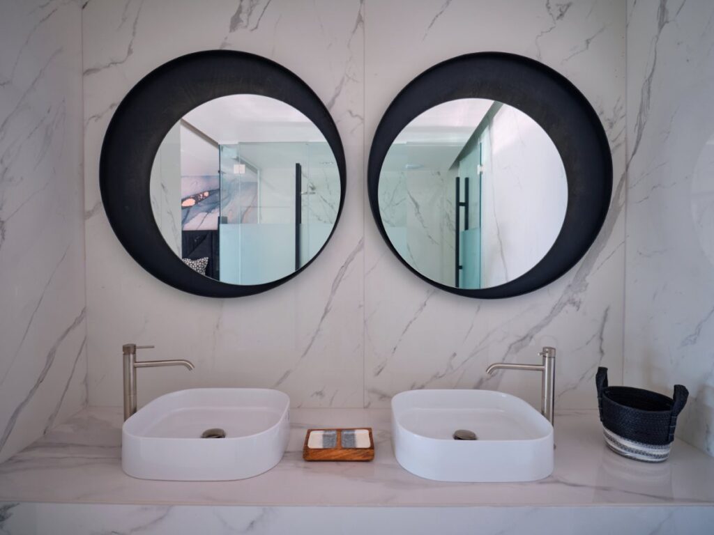 Sophisticated mirrors, marble, and a modern bathroom in the best vacation home to stay in, Mykonos.