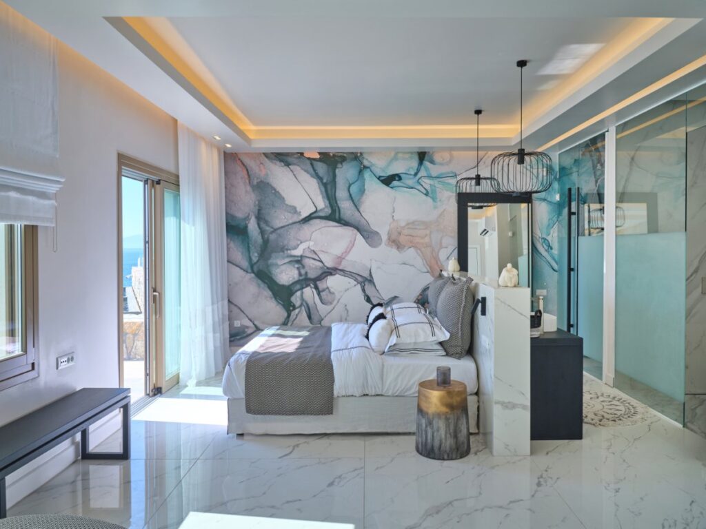 Elegant white and soft blue shades bedroom with a terrace in Mykonos lush villa for rent.