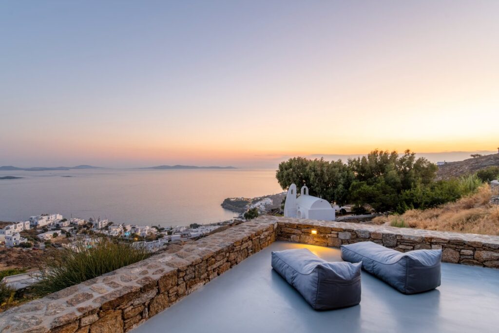 Experience the Mykonos booking holiday villa's comfy terrace and stunning sunset scenery.