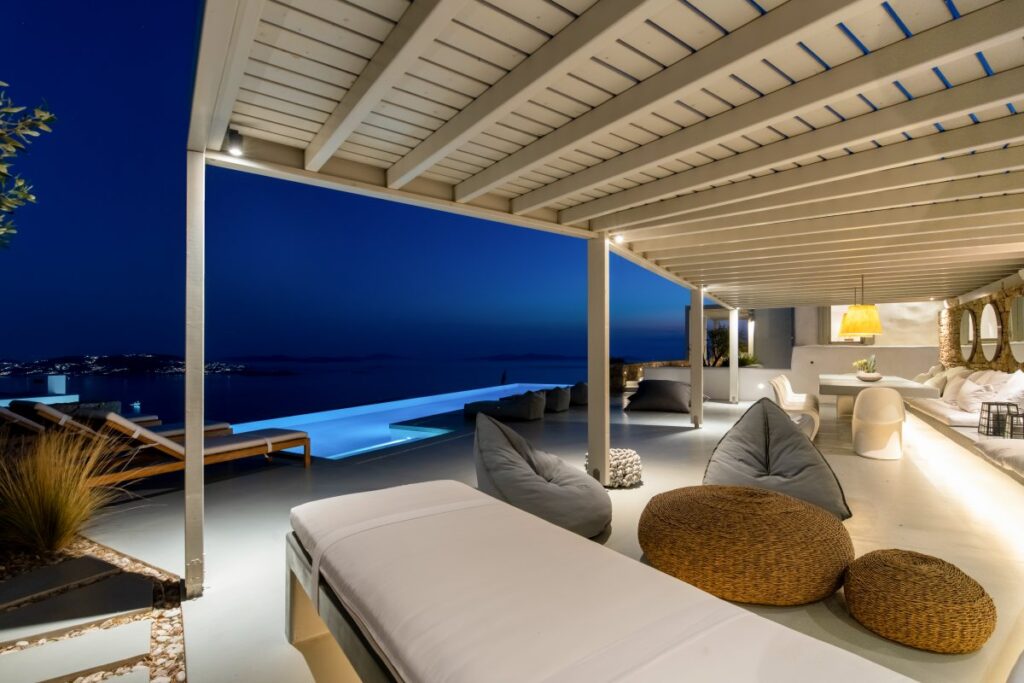 Mykonos Villa with an exceptional infinity pool by night and a modern terrace for gathering.