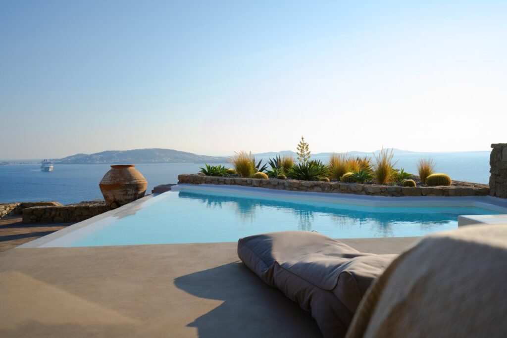 Private rental villa in Mykonos with a clear blue infinity pool and stunning view of the Aegean sea.