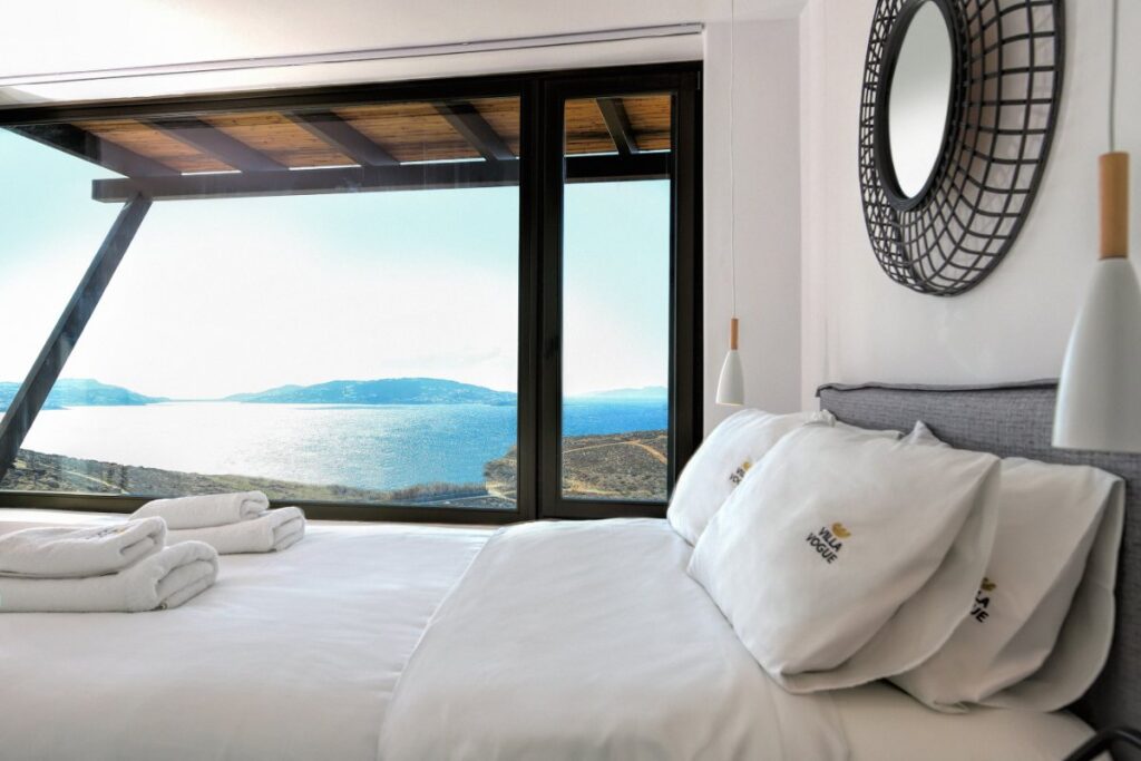 Bright and comfortable bedroom with the best view of the Aegean sea in Mykonos villa for rental, Greece.