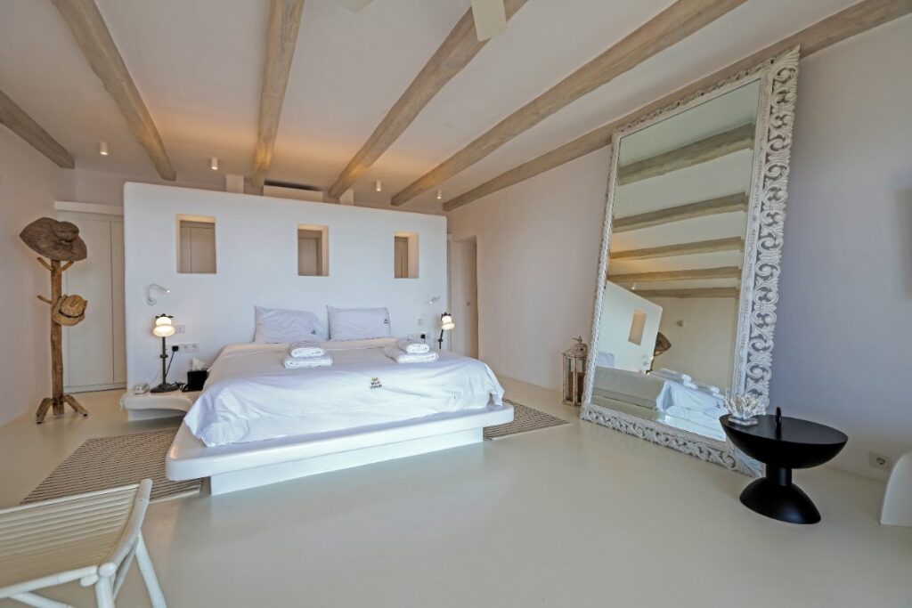 Enjoyable and spacious bedroom with a huge white luxurious mirror in Mykonos private home for rent