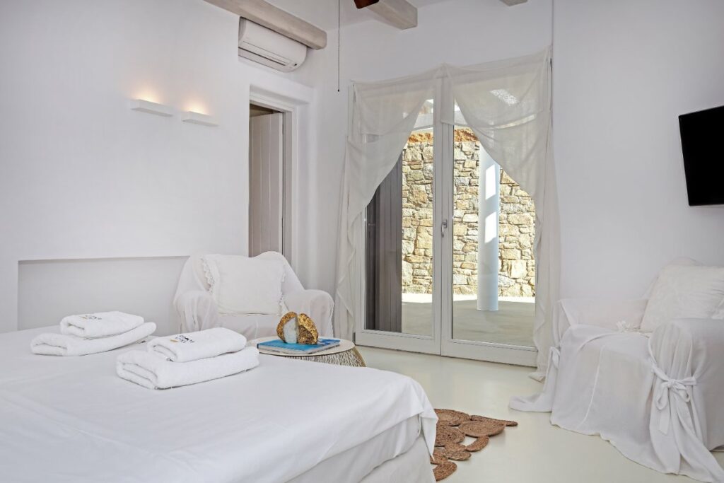 White walls and the pleasant look of a bedroom in the best villa, Mykonos. Gorgeous white furniture.