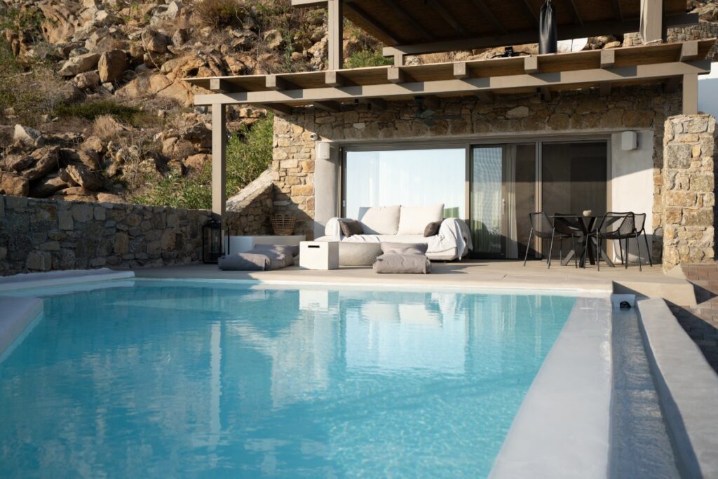 Luxury private home for rent in Mykonos with an infinity pool and cozy modern sofa for chilling outside.