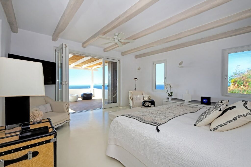 High-quality bedroom with a private terrace in Mykonos waterfront villa for rental, Greece.