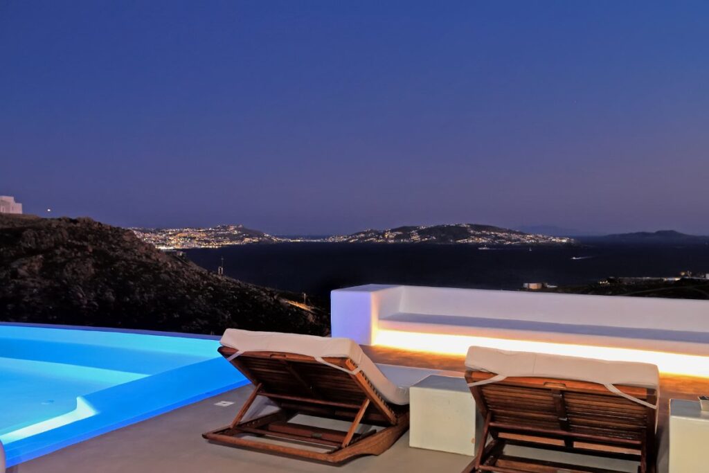 Sun beds and a breathtaking view from the luxurious terrace in a best rental private home in Mykonos, Greece.