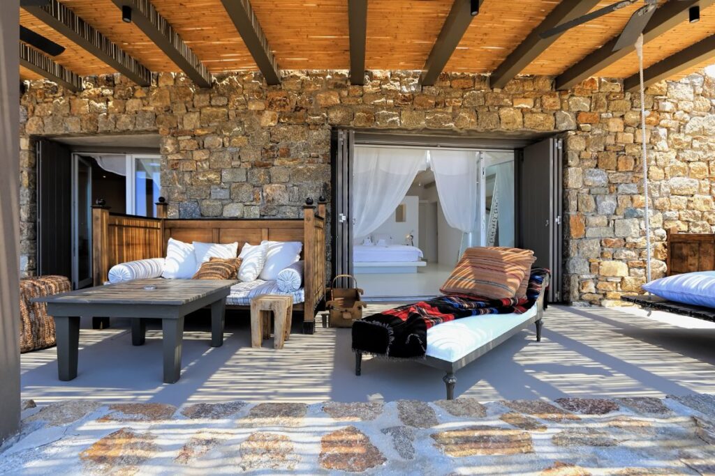 Traditionally Greeks decorated outside spaces with sun beds and wooden covers in the splendid rental villa, in Mykonos, Greece.