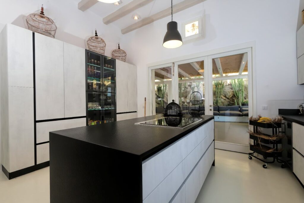 Stylish black and white kitchen in Mykonos holiday rental villa with a sophisticated bar and plenty of lighting