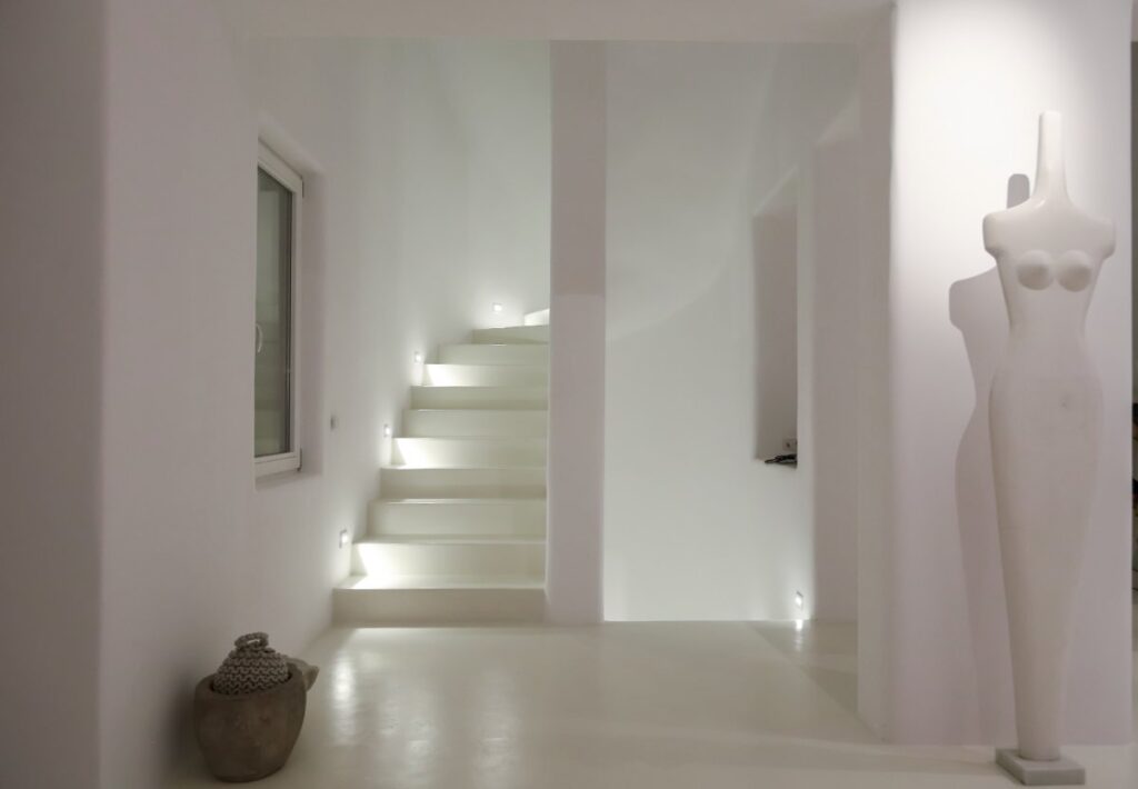 White artistic hall with a smooth textured staircase in vacation rental home in Mykonos, Greece