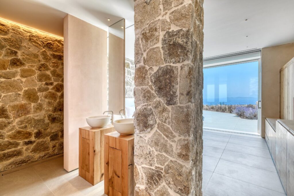Lavish sinks, and white and stone-decorated walls in Mykonos splendid rental home.