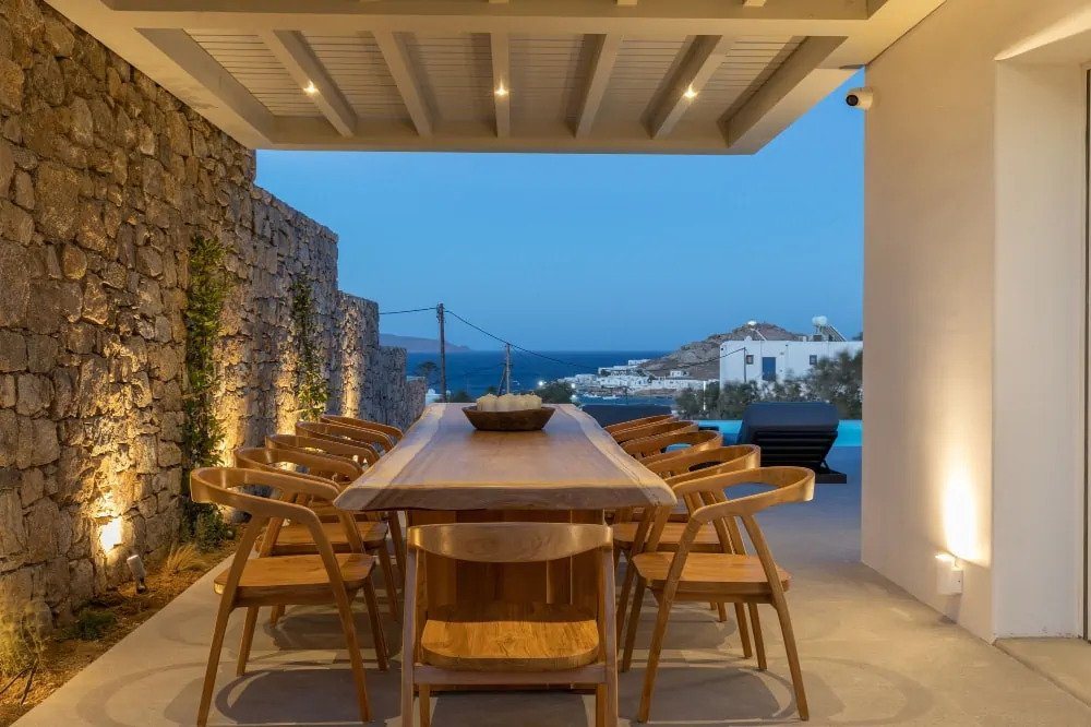 Modern wooden out space dining table with a fantastic sea view in a private rental home, Mykonos.