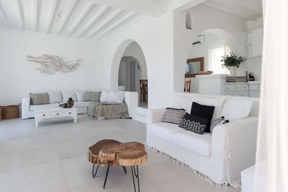 Stylish modern living room with enjoyable white and wooden furniture in Mykonos lavish rental villa, Greece.