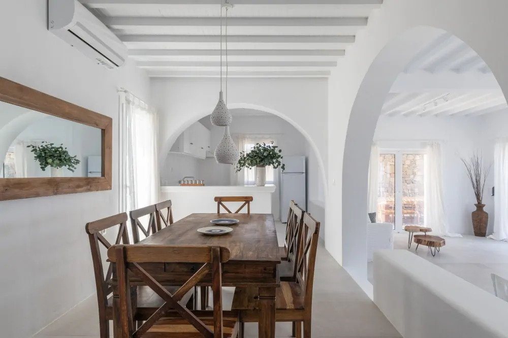 Mykonos secluded villa's dining room with dark brown wooden table and chairs, convenient for numerous groups of people