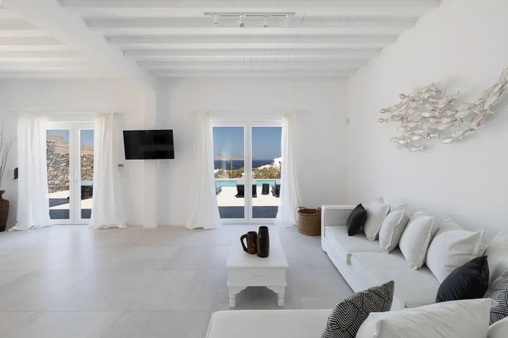 Pure white living room and white walls as the perfect backdrop in the lavish rental villa, in Mykonos, Greece.