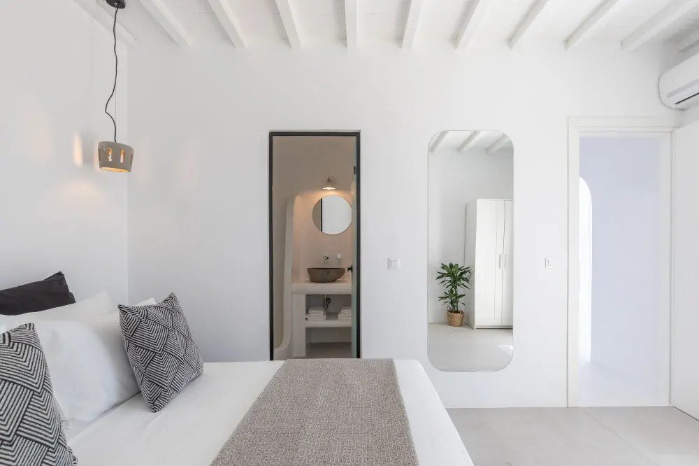 White-cream stylish bedroom, mirrors, and relaxing atmosphere in Mykonos finest rental villa