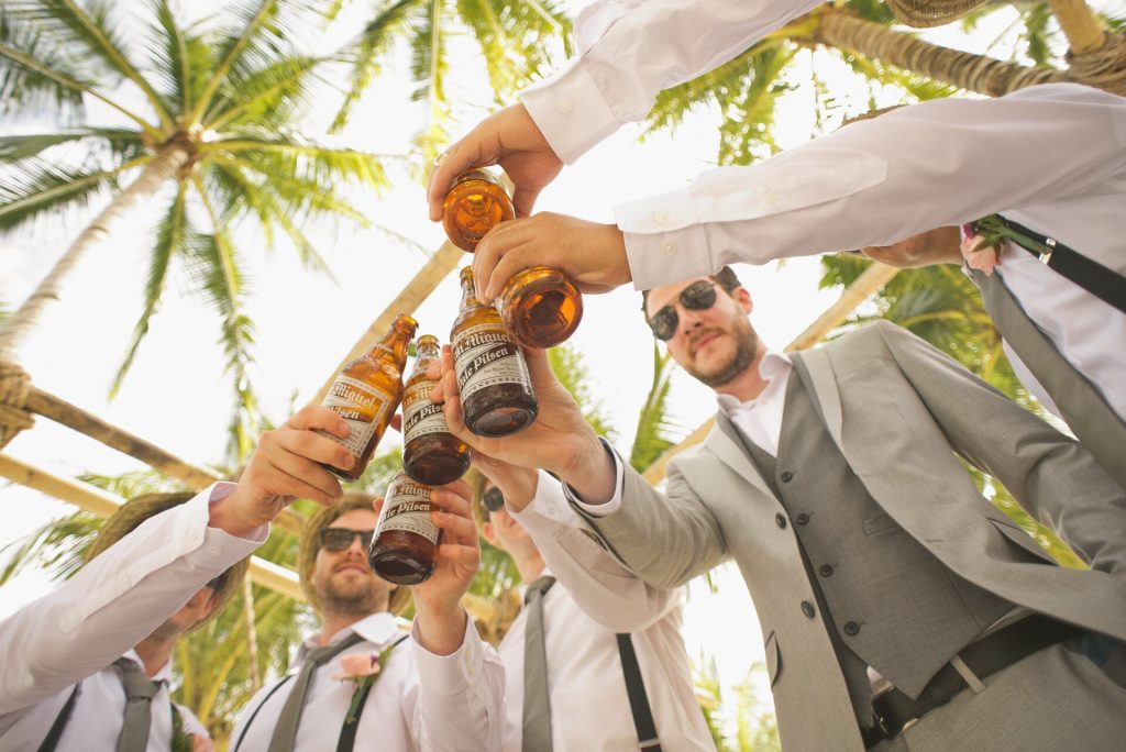 A group of friends holding bottles of beer