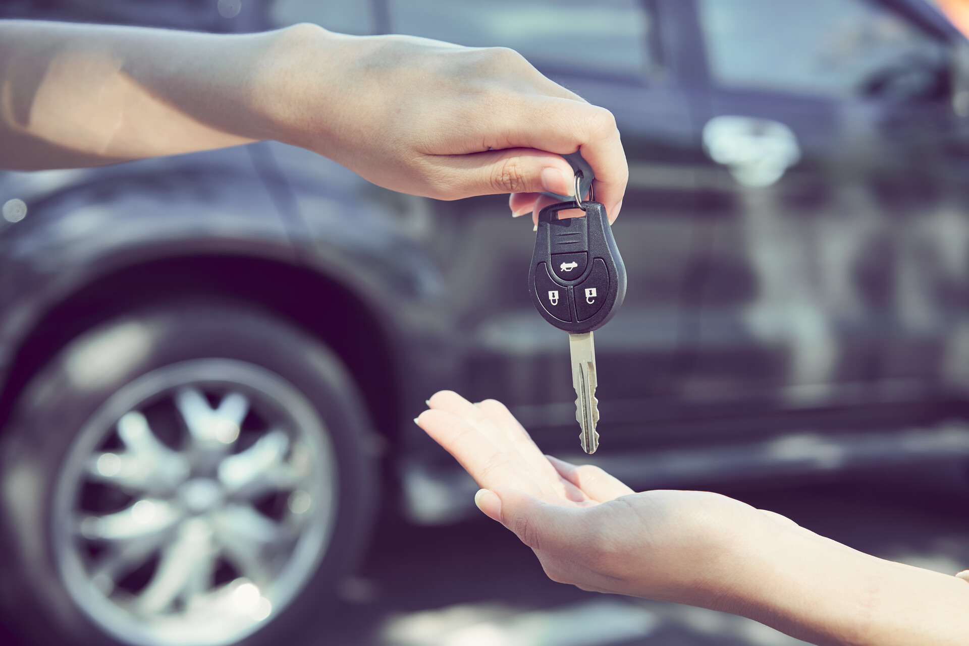 A person handing someone car keys