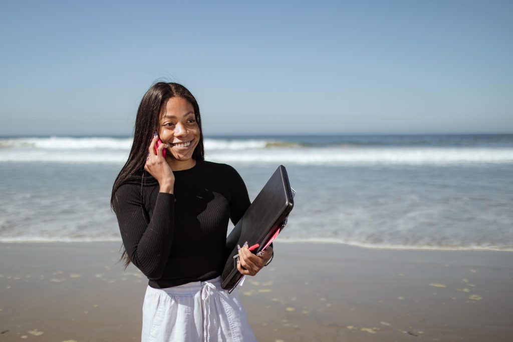 Girl walking by the sea and talking on her phone