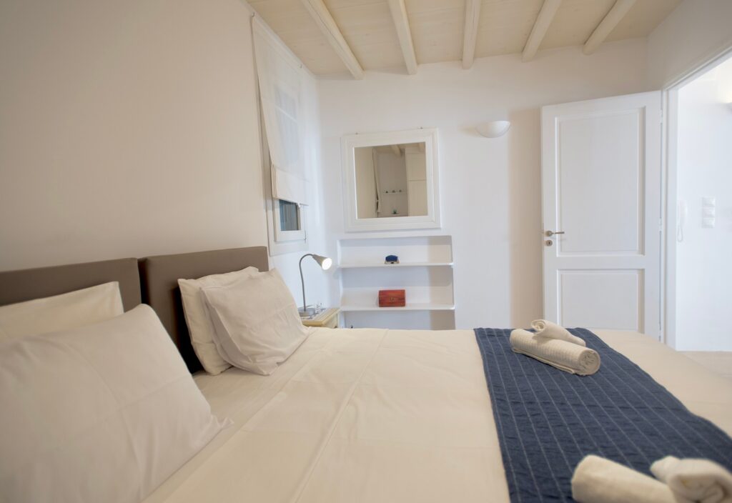 Comfortable bed and white walls, lavish Mykonos villa for rent.