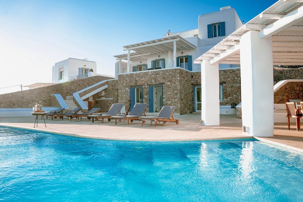 Sun beds and an amazing infinity pool in a top rental home in Mykonos, Greece.
