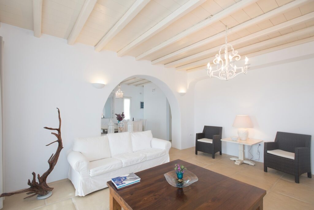 White walls and wooden furniture in the living room of the best villa to stay in, Mykonos.