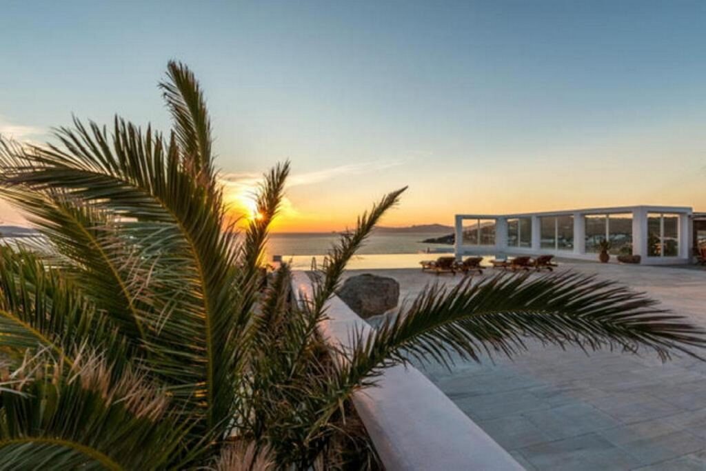 Palm tree, sea view, and sunset from Mykonos lavish villa for rent.
