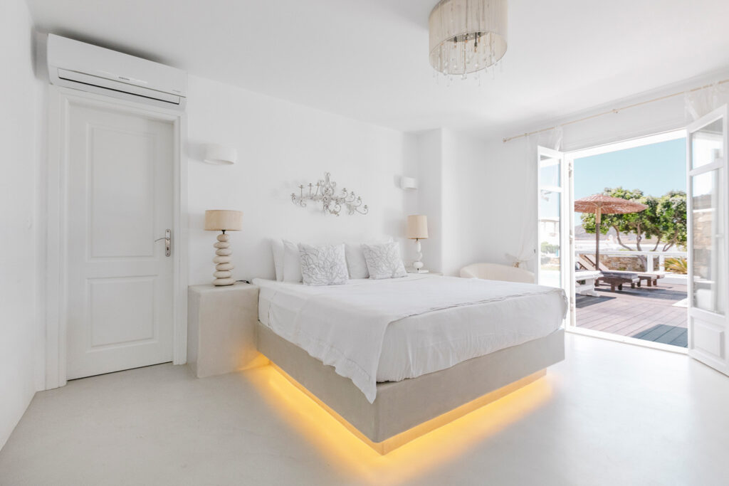 Lavish bedroom with access to a terrace and swimming pool in Mykonos best villa for booking.