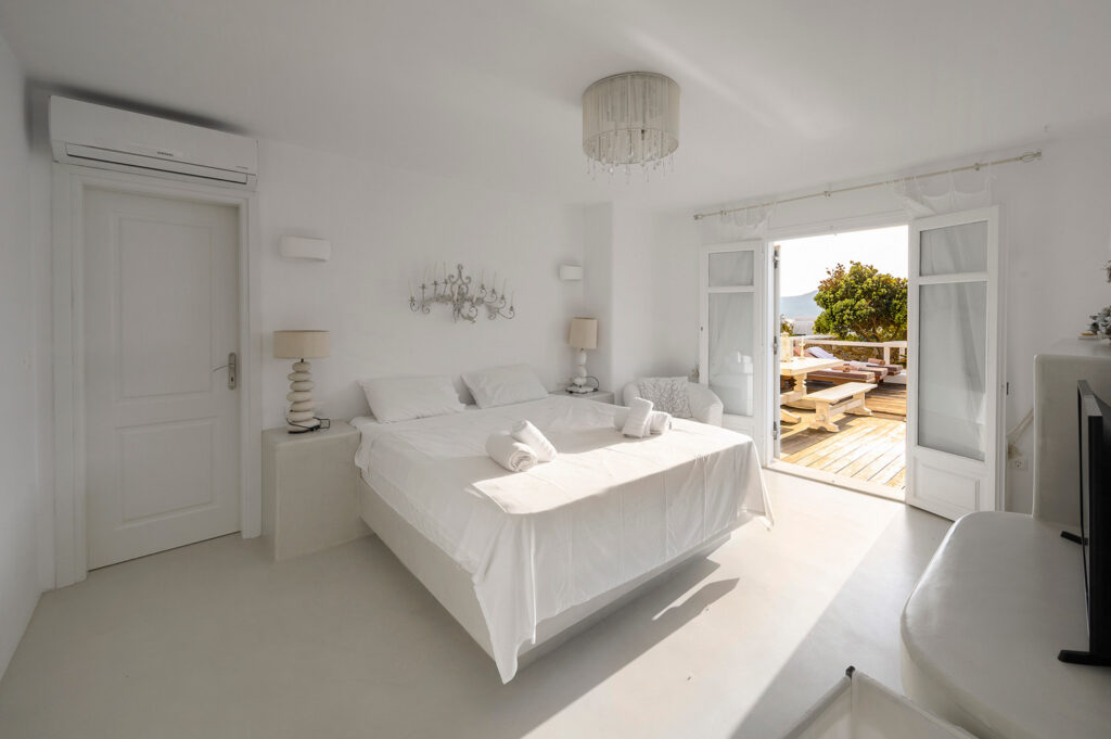 Sophisticated bedroom with a terrace in Mykonos holiday villa for rent.