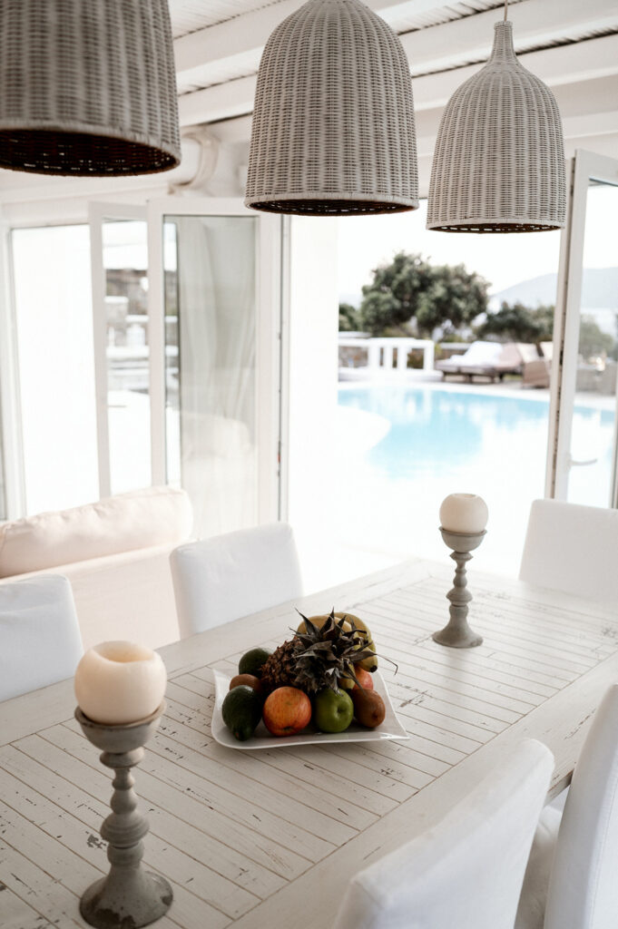 Chandelier, fruits, and candles on a table in Mykonos' top vacation home for rent.
