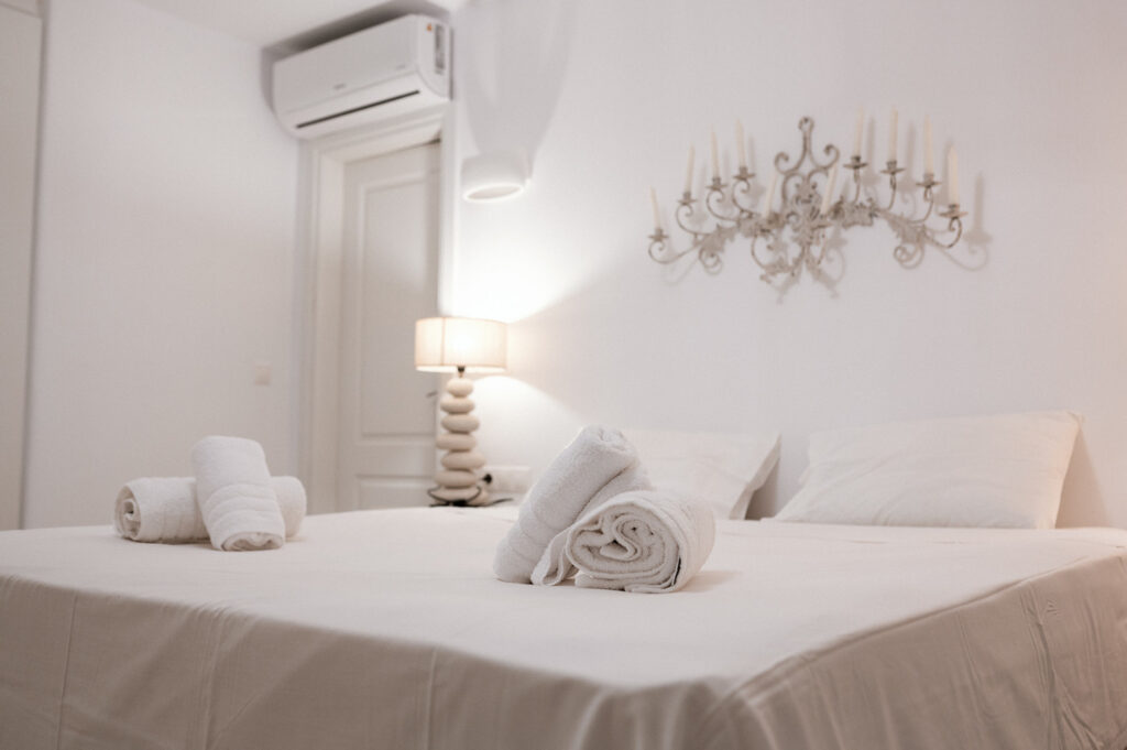 Luxurious comfort of a spacious bed and cozy pillows and towels in Mykonos rental home.