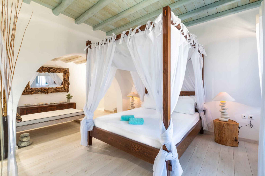 Comfortable bed with canopies in Mykonos villa for rent.