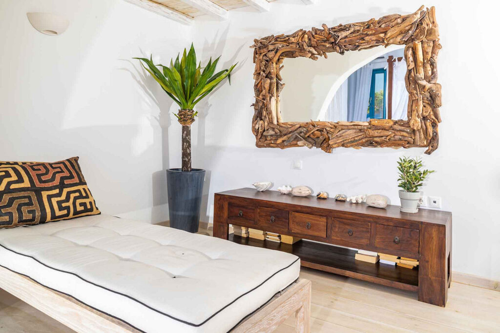 Cozy corner with a bed and a mirror within a lavish villa for rent, Mykonos.