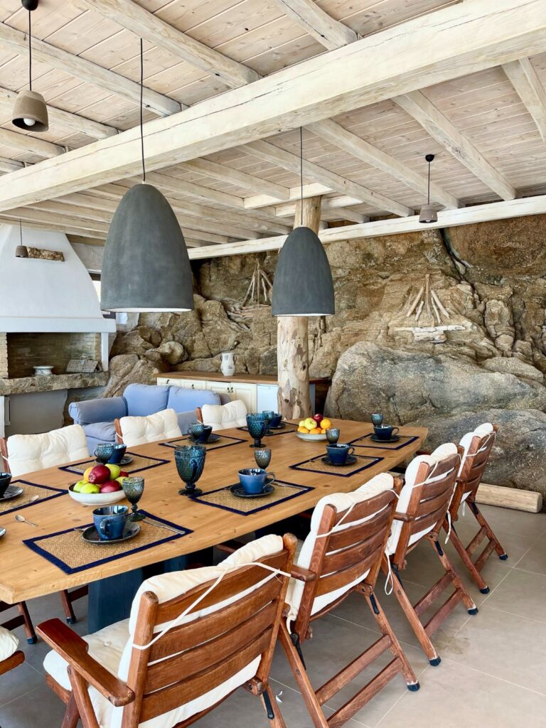Wooden out space dining table with in a private rental home, Mykonos.
