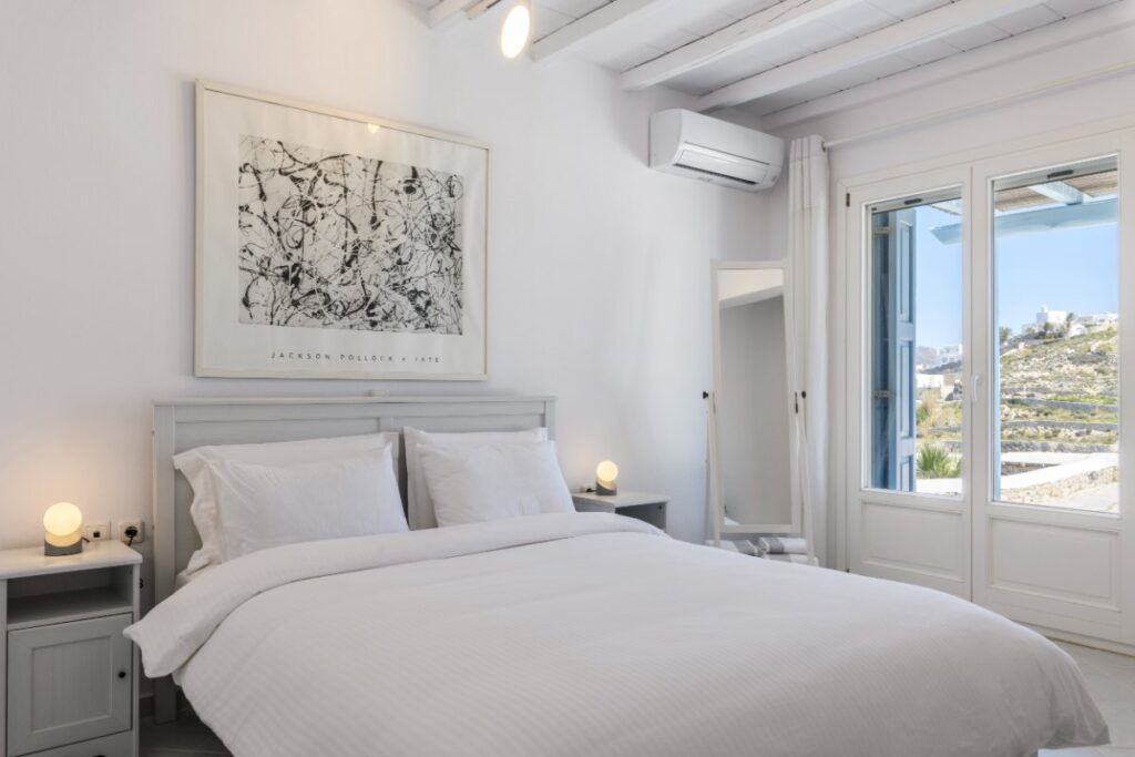 A luminous bedroom with high-quality beds and a beautiful view of nature, Mykonos villa is for rent.