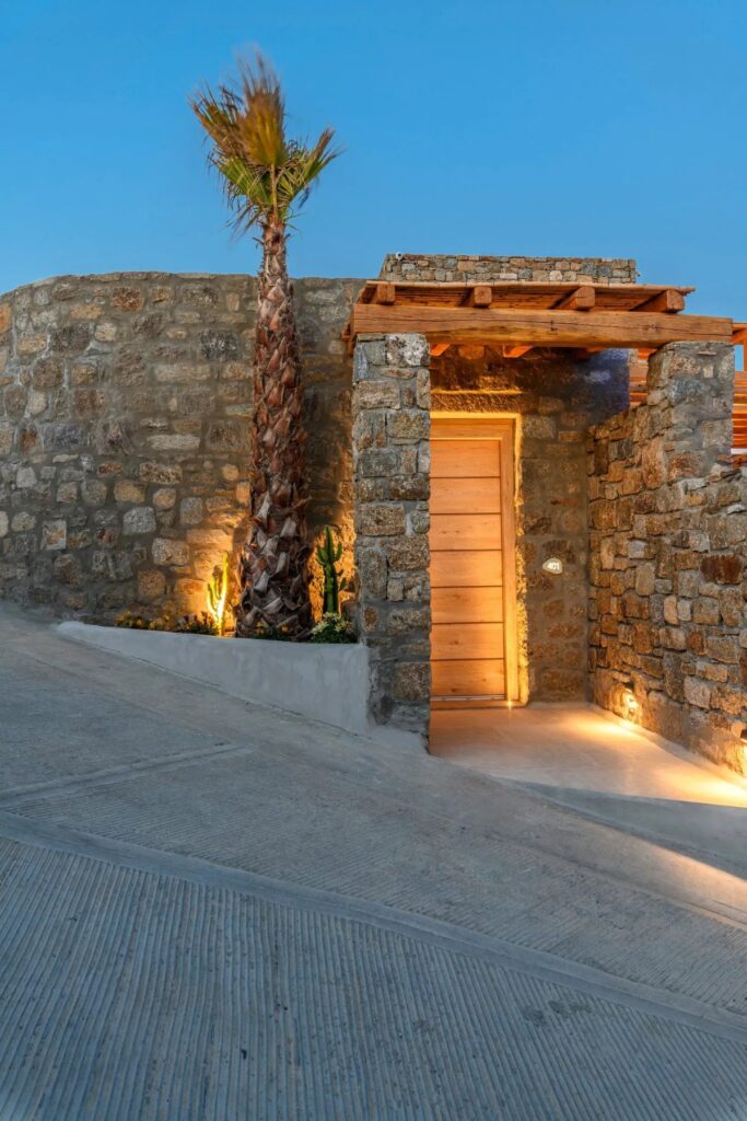 Palm tree and an entrance into the best vacation home for booking, Mykonos.