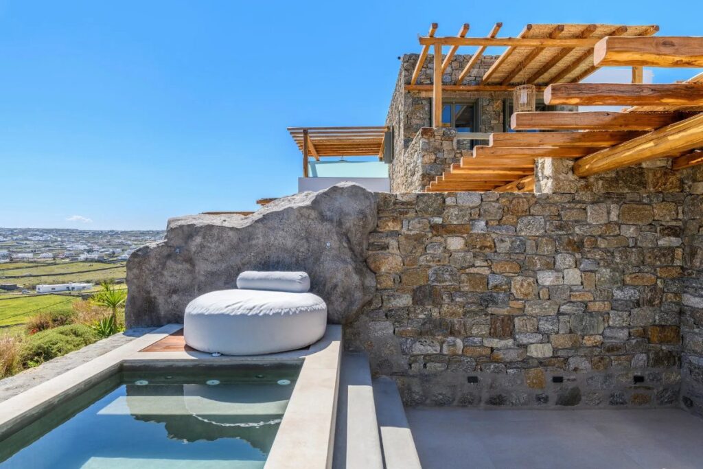 Wooden and stone design of a modern terrace in a deluxe villa for rent, Mykonos.