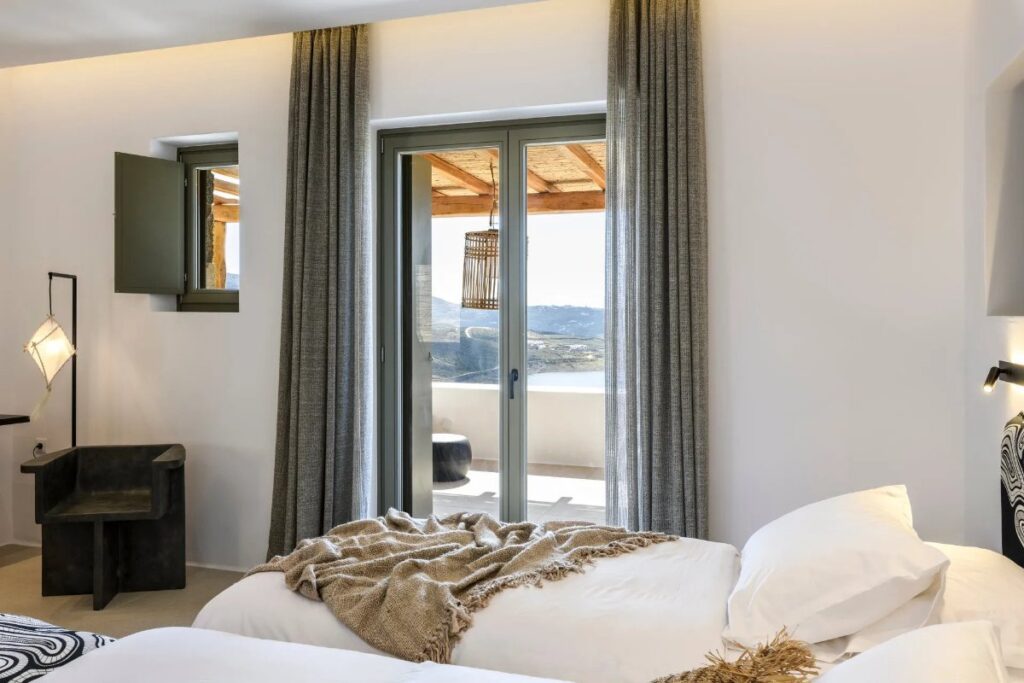 Comfy bedroom with access to the terrace in lavish Mykonos villa for rent.