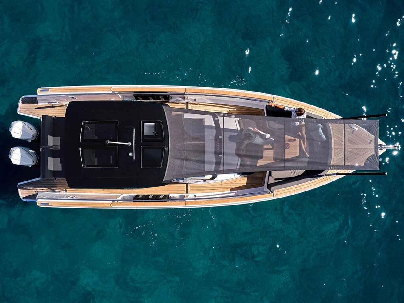 A top-down view of a small yacht at sea with a couple onboard