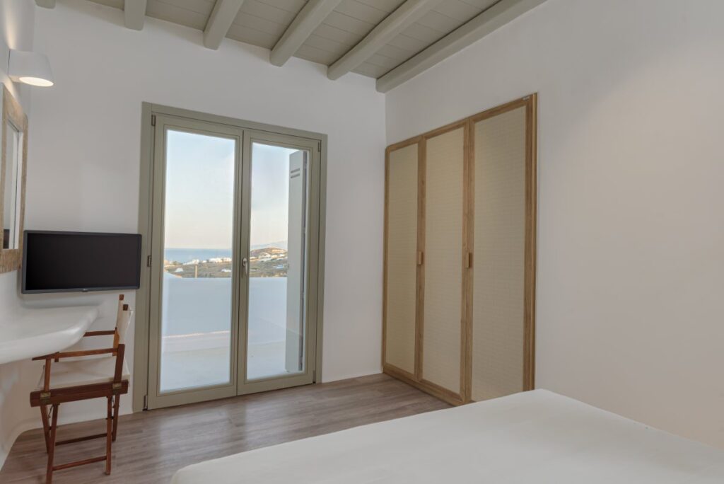 Modern and cozy bedroom with a view of the Aegean Sea, Mykonos rental villa.